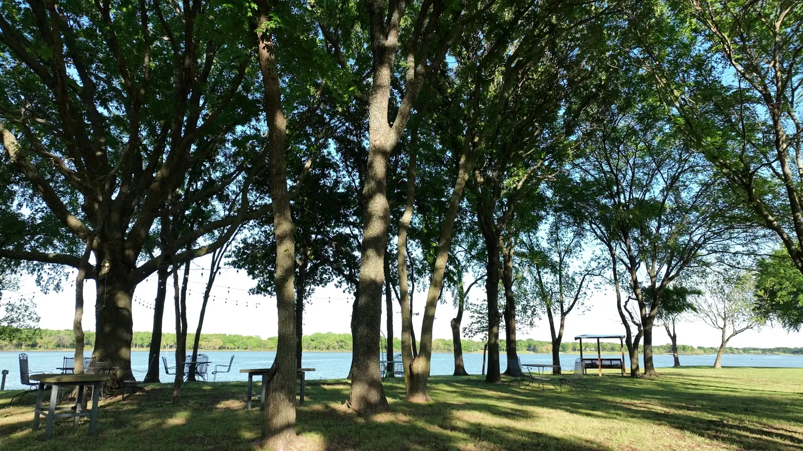 Picnic tables under the oaks along the shoreline at Waterfront Hideaway Ranch